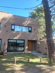 a house with a tree in front of it at Senderos del Mar in Monte Hermoso