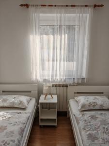 a bedroom with two beds and a window at Apartma S&M in Koper