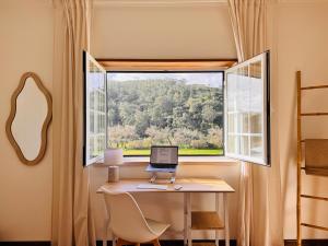 a window with a laptop on a desk in a room at Casa Nabia - Coastal Sanctuary in Ericeira