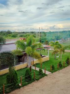 a park with palm trees in front of a building at Hotel Fazenda Arena Green in Cajazeiras