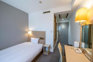 a bedroom with a bed and a desk and a computer at 大和パークホテル in Taiwa