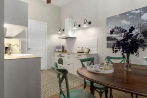a kitchen with a wooden table and green chairs at MARITXU'S HOME in San Sebastián