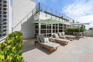 a patio with chairs and umbrellas on a building at Bentley Hotel South Beach in Miami Beach