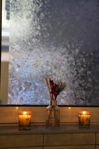 un tavolo con candele e fiori in un vaso con luci di MiM LUX a Gornji Milanovac