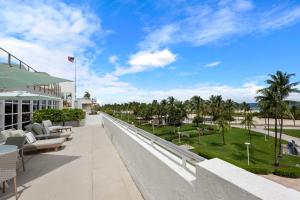 a balcony of a resort with chairs and palm trees at Bentley Hotel South Beach in Miami Beach +63 photos