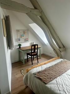a bedroom with a desk and a chair and a bed at Appartements Lambotte in LʼAigle