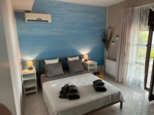 a bedroom with a bed with a blue wall at Sea You - Apartments in Avlákia +56 photos