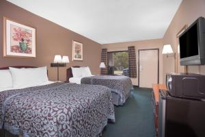a hotel room with two beds and a flat screen tv at Days Inn by Wyndham Dublin GA in Dublin +23 photos