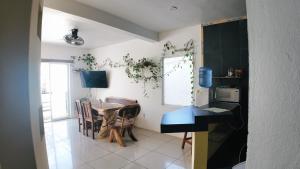 a kitchen and dining room with a table and a desk at BRISAMAR GUESTHOUSE in Puerto Escondido