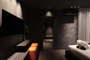 a black room with a bed and a bench and a couch at B Suite Spa in Palermo