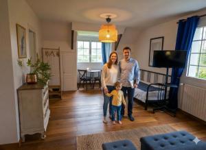 a man and a woman and a child standing in a living room at Bed and Breakfast Saultchevreuil in Villedieu-les-Poêles