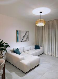 a living room with a white couch and a chandelier at Victoria's home near the beach with Swimming pool and elevator in Punta Cana +20 photos