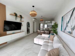 a living room with a white couch and a tv at Victoria's home near the beach with Swimming pool and elevator in Punta Cana