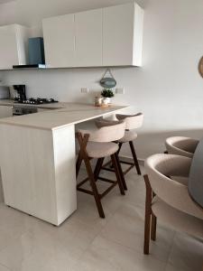 a kitchen with white cabinets and a table and chairs at Victoria's home near the beach with Swimming pool and elevator in Punta Cana