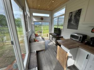 a tiny house with a living room and a tv at Mountain View Retreat in Creston