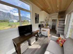 a living room with a couch and a television in a tiny house at Mountain View Retreat in Creston