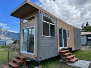 a tiny house with benches in a field at Mountain View Retreat in Creston
