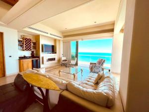 a living room with a couch and a view of the ocean at Ocean Wrap Around Oceanfront Balcony at Tessoro in Las Conchas