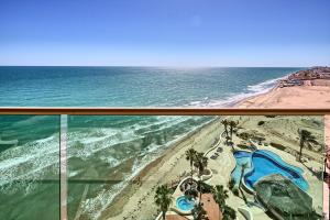 a view of the beach from the balcony of a resort at Ocean Wrap Around Oceanfront Balcony at Tessoro in Las Conchas