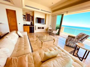 a living room with a couch and a view of the ocean at Ocean Wrap Around Oceanfront Balcony at Tessoro in Las Conchas +30 photos