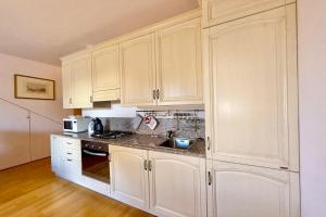 a kitchen with white cabinets and a sink at Mastena Elegante in San Siro