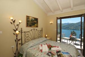 a bedroom with a bed with a view of the water at Le Petit Palais Villa in Plesio