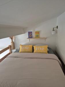 a bedroom with a large bed with yellow pillows at Appartement avec piscine proche plages in Cap d'Agde