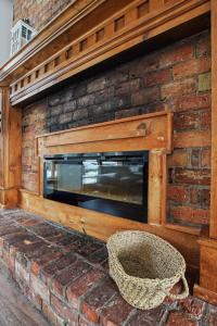 a brick wall with a fireplace with a television on it at Birch View- Balcony-Backyard-Parking-Sauna-Sleeps 20 in Blue Mountains