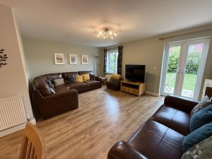a living room with leather couches and a television at Anchors Away at The Bay Filey, sleeps 7, 2 dogs welcome for free too in Filey