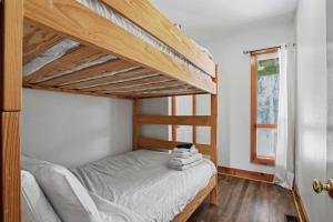 a bedroom with a bunk bed and a window at Birch View- Balcony-Backyard-Parking-Sauna-Sleeps 20 in Blue Mountains