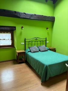 a green bedroom with a bed with a green wall at rincón de covadonga in Caño