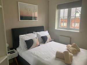 a bedroom with a bed with white sheets and pillows at Caramel Cottage at The Bay Filey, sleeps 6, 2 dogs welcome for free too in Filey +24 photos