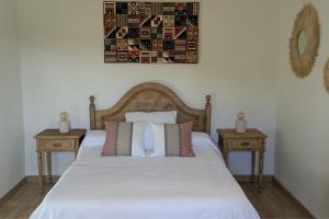 a bedroom with a white bed with two night stands at Casa de campo La Casuca Del Monje, San Vicente de la Barquera in La Acebosa