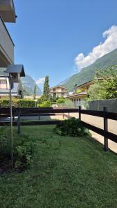 a fence in a yard with mountains in the background at La casa delle margherite - Tirano in Tirano