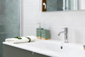a bathroom sink with a towel and a faucet at Verde Appartamento Moderno in Monserrato +39 photos