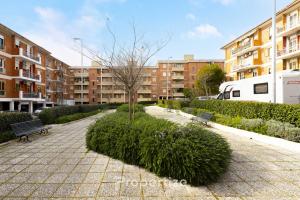 a park with a tree and benches and buildings at Verde Appartamento Moderno in Monserrato