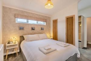 a bedroom with a large white bed and a window at 3 Bed in Tallington oc-s30309 in Yaxley