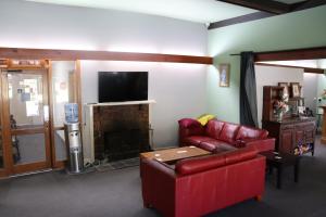 a living room with a red couch and a fireplace at Flowerdale Hotel in Flowerdale +9 photos