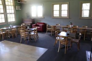 a dining room with tables and chairs and windows at Flowerdale Hotel in Flowerdale