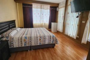 a bedroom with a bed and a flat screen tv at Refugio del Lago in Puno