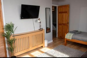 a bedroom with a tv on the wall and a bed at Inskeyft - Kirkwall in Kirkwall