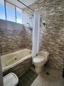 a bathroom with a tub and a toilet and a sink at Refugio del Lago in Puno