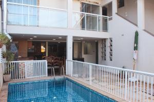 a house with a swimming pool next to a building at Pousada Porto Maresias in Cabo Frio