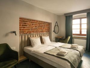 a bedroom with a bed with a brick wall at Arte-locum Apartamenty przy Rynku in Wrocław