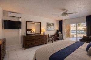 a bedroom with a bed and a dresser with a mirror at Palms Resort and Beach in La Grande Princesse