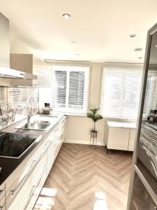 a kitchen with white cabinets and a sink and windows at Fewo Anna in Bernkastel-Kues