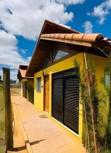 a yellow house with a garage at Vinhedo Villarejo - Chalés do Vinhedo in Paty do Alferes