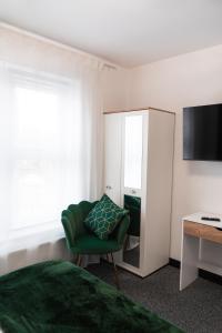 a bedroom with a green chair and a mirror at Bristol Boutique Stay in Bristol