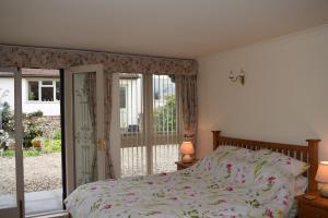 a bedroom with a bed and a sliding glass door at Sandhurst Farm Forge in Sittingbourne