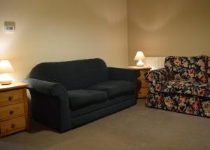 a living room with a couch and a chair at Sandhurst Farm Forge in Sittingbourne +8 photos
